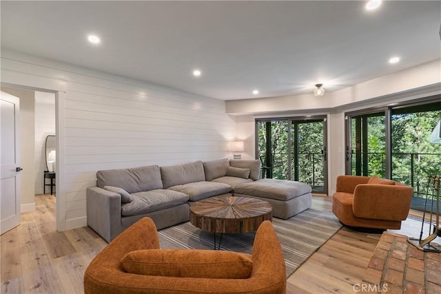 living room featuring light wood-type flooring and wooden walls