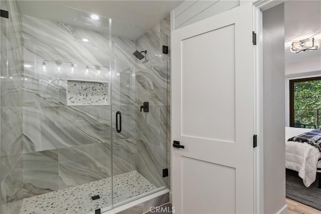 bathroom with a shower with door and hardwood / wood-style flooring