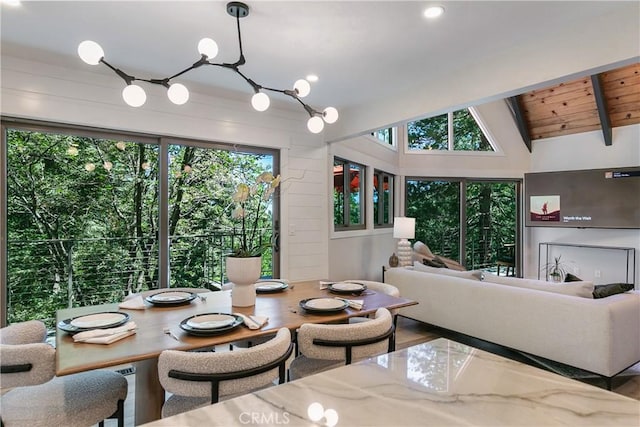 dining area with vaulted ceiling with beams, wooden ceiling, and a wealth of natural light