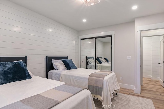 bedroom with light hardwood / wood-style floors and a closet