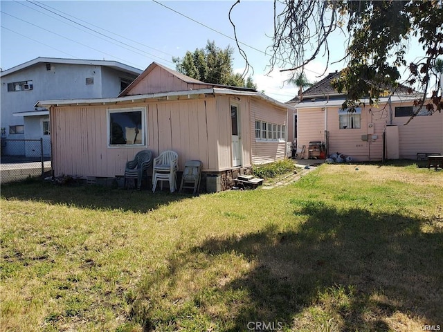 rear view of house featuring a lawn