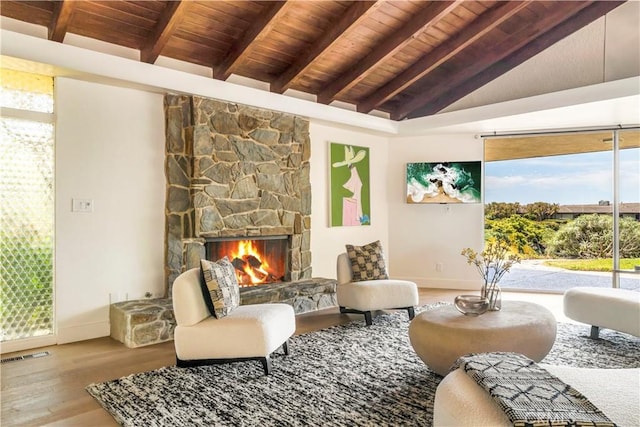 interior space featuring a fireplace, vaulted ceiling with beams, hardwood / wood-style flooring, and wooden ceiling