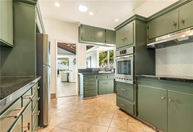 kitchen featuring tasteful backsplash, stainless steel appliances, and green cabinetry