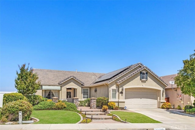 ranch-style house with solar panels, a garage, and a front lawn