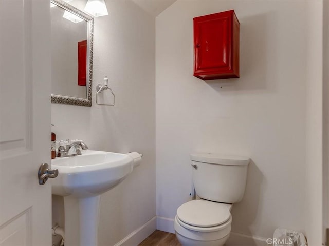 bathroom with wood-type flooring, toilet, and sink