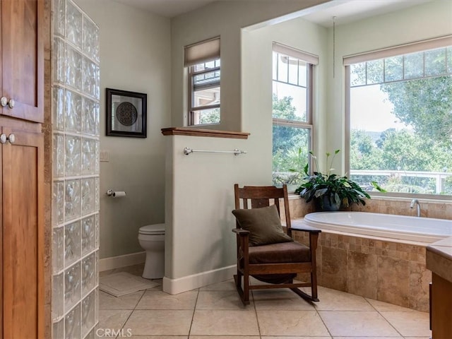 bathroom with tile patterned flooring, toilet, and tiled tub