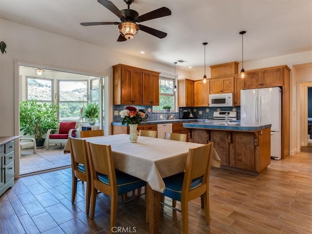 dining space featuring ceiling fan and sink