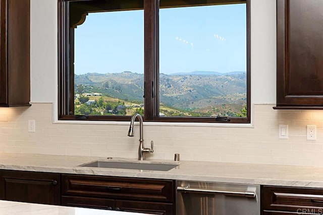 kitchen featuring decorative backsplash, a mountain view, sink, and dark brown cabinets