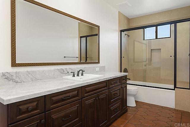 full bathroom featuring tile patterned floors, vanity, toilet, and bath / shower combo with glass door