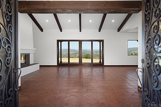 tiled living room with lofted ceiling with beams, a mountain view, and a fireplace