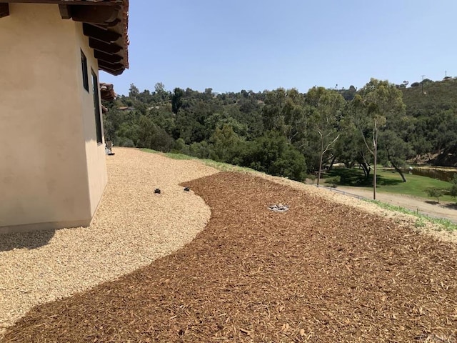 view of yard with a view of trees
