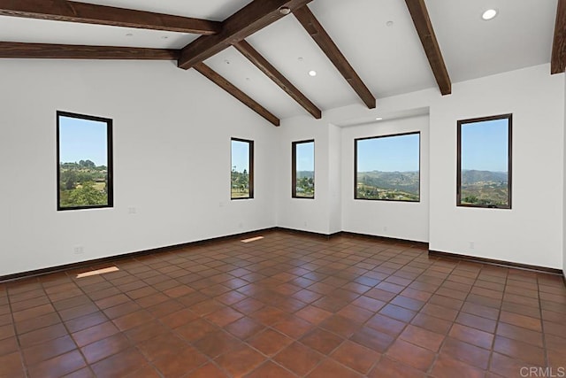 unfurnished room featuring a wealth of natural light, recessed lighting, dark tile patterned floors, and lofted ceiling with beams