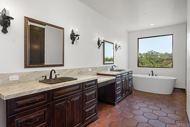 bathroom with a freestanding bath, recessed lighting, vanity, and tile patterned flooring