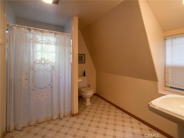 bathroom with sink, toilet, tile patterned floors, and vaulted ceiling