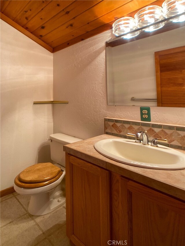 bathroom featuring wood ceiling, decorative backsplash, tile patterned floors, toilet, and vanity