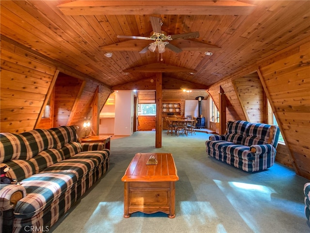 carpeted living room featuring wood walls, ceiling fan, vaulted ceiling with beams, and wood ceiling