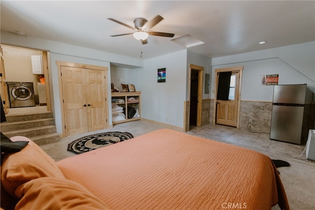 carpeted bedroom with stainless steel fridge, washer / dryer, and ceiling fan