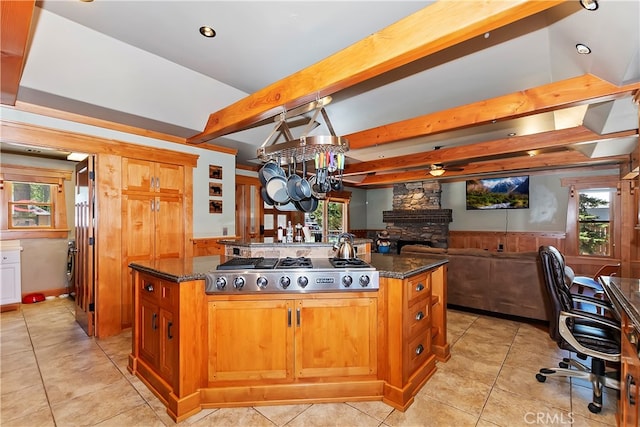 kitchen featuring a center island with sink, plenty of natural light, and light tile floors