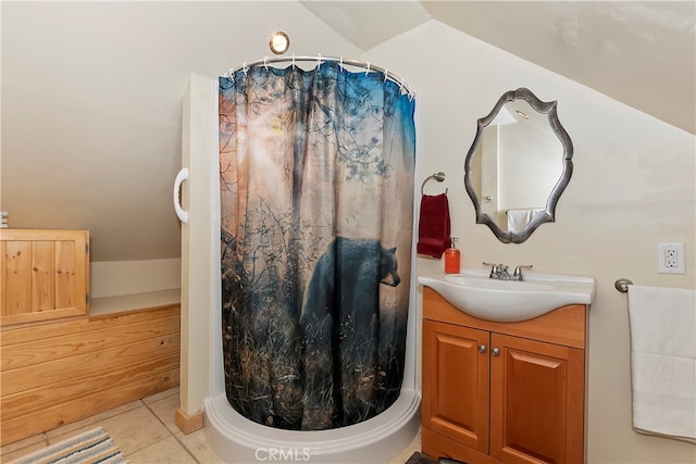 bathroom featuring tile floors, lofted ceiling, and large vanity