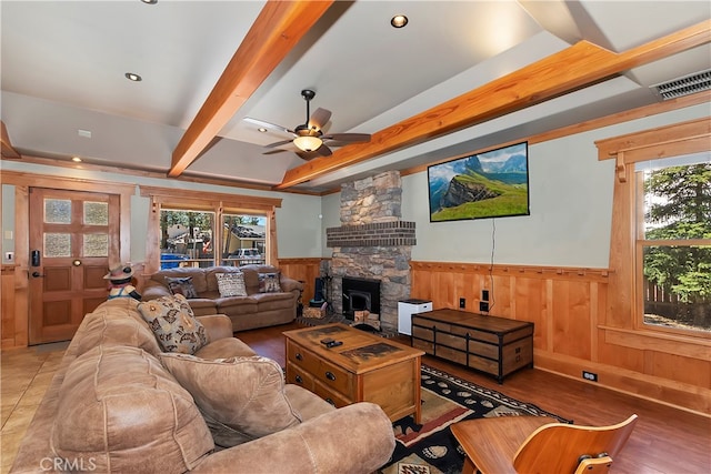 living room with beam ceiling, plenty of natural light, ceiling fan, and a fireplace