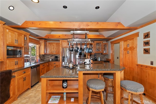 kitchen featuring tasteful backsplash, stainless steel appliances, light tile flooring, a kitchen island, and sink