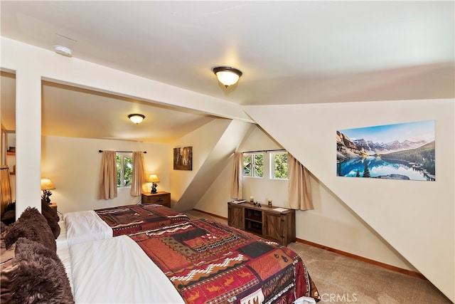 bedroom with lofted ceiling, carpet, and multiple windows