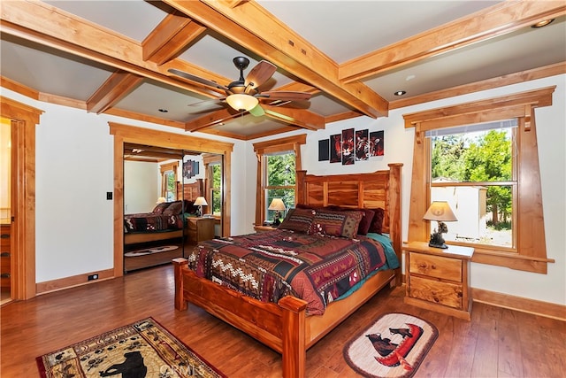 bedroom with beam ceiling, multiple windows, and dark hardwood / wood-style flooring