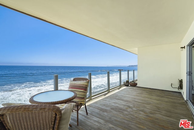 balcony featuring a water view and a view of the beach