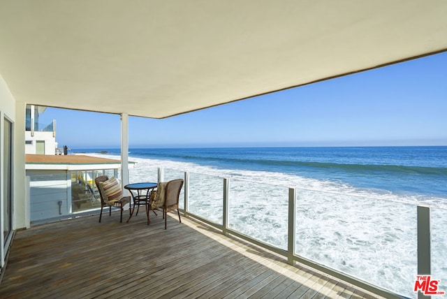 balcony with a water view and a beach view