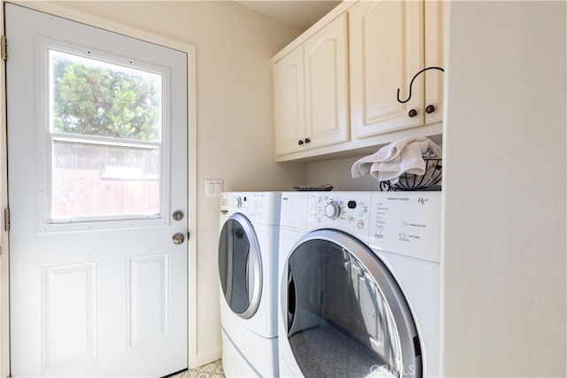 laundry room featuring washing machine and dryer and cabinets