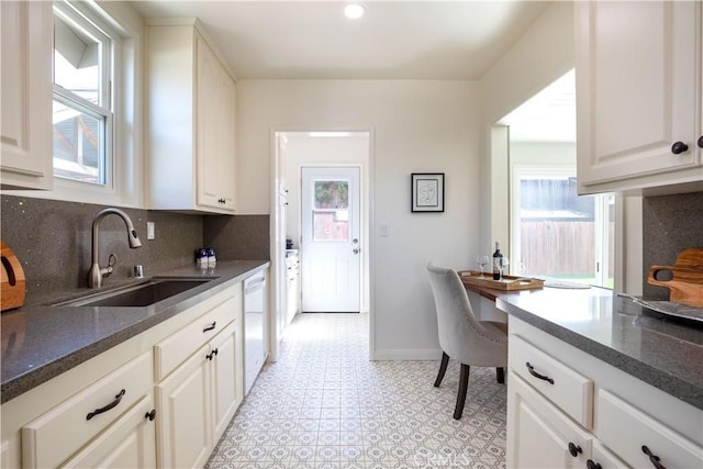 kitchen with sink, white cabinetry, tasteful backsplash, plenty of natural light, and white dishwasher