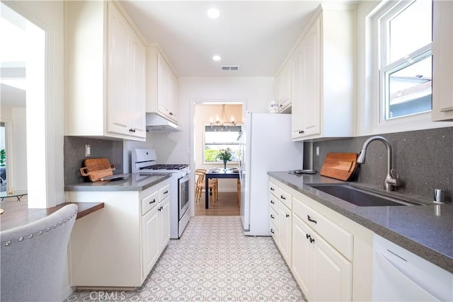 kitchen with tasteful backsplash, white appliances, sink, and white cabinets