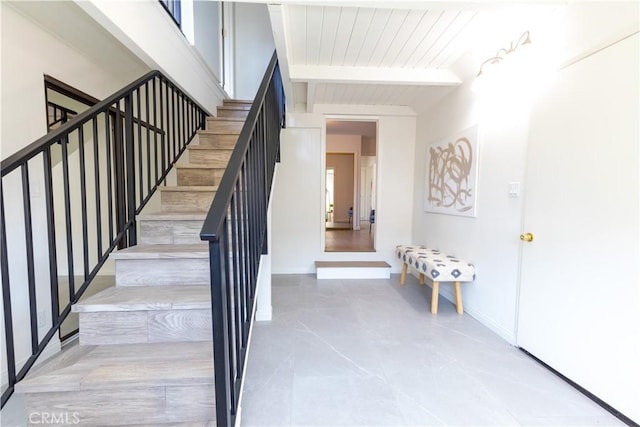 stairway with beamed ceiling