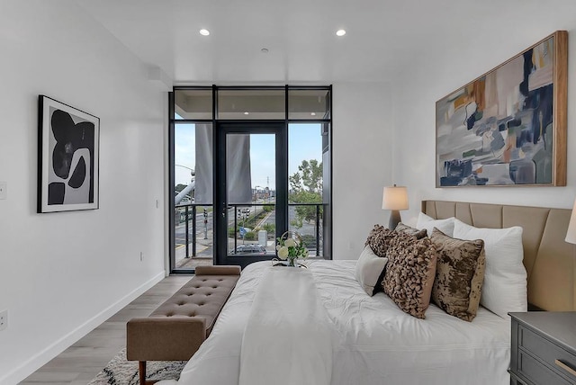 bedroom featuring access to outside, expansive windows, and wood-type flooring