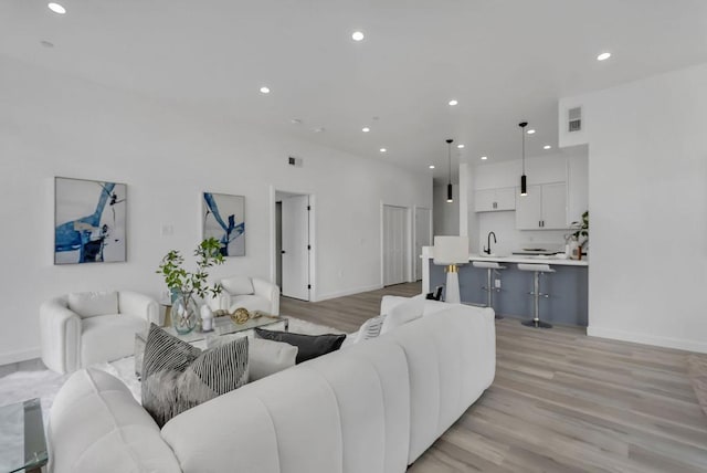 living room with sink and light hardwood / wood-style flooring