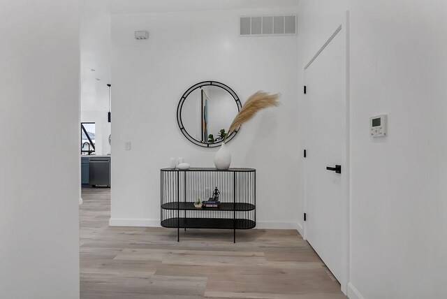 corridor featuring sink and light wood-type flooring