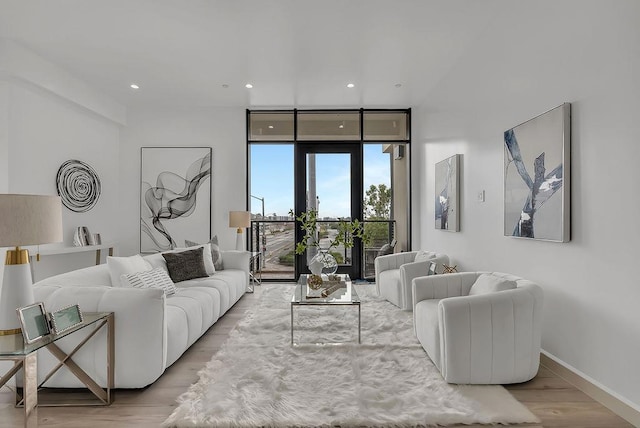 living room featuring a wall of windows and light wood-type flooring