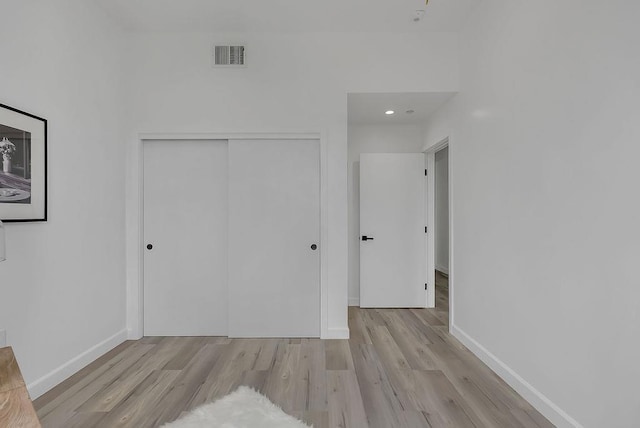 unfurnished bedroom featuring a closet and light hardwood / wood-style flooring