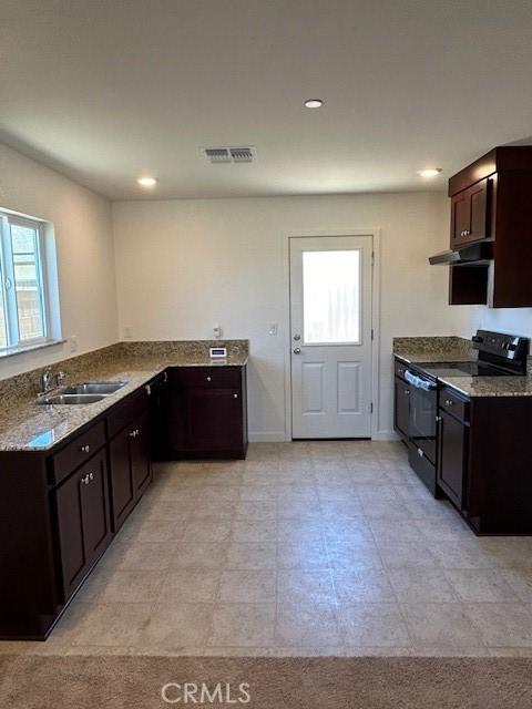 kitchen with sink, dark brown cabinets, black electric range, light stone countertops, and kitchen peninsula