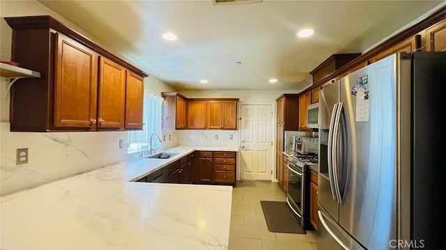 kitchen featuring sink, stainless steel appliances, light stone counters, backsplash, and light tile patterned floors