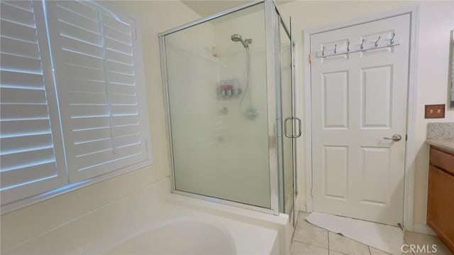 bathroom with tile patterned flooring, vanity, and walk in shower