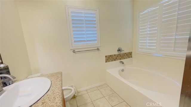 bathroom with tile patterned floors, a washtub, vanity, and toilet