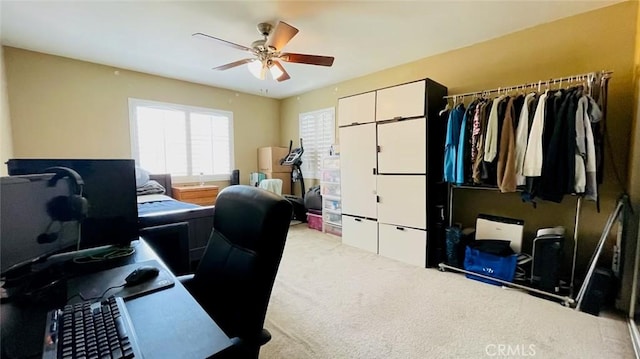 carpeted office space with ceiling fan