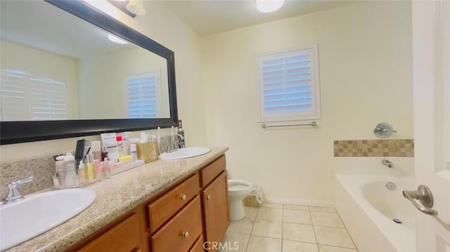 bathroom with tile patterned floors, a tub, vanity, and toilet