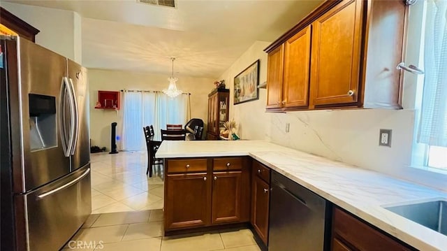 kitchen featuring kitchen peninsula, appliances with stainless steel finishes, pendant lighting, an inviting chandelier, and light tile patterned flooring