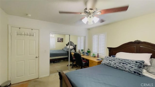 carpeted bedroom featuring ceiling fan and a closet