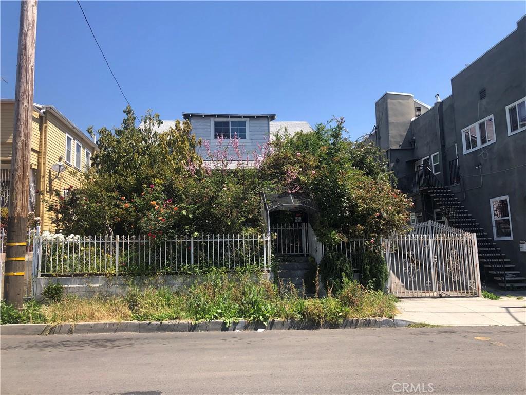 view of front of property featuring a fenced front yard, a gate, and stairway