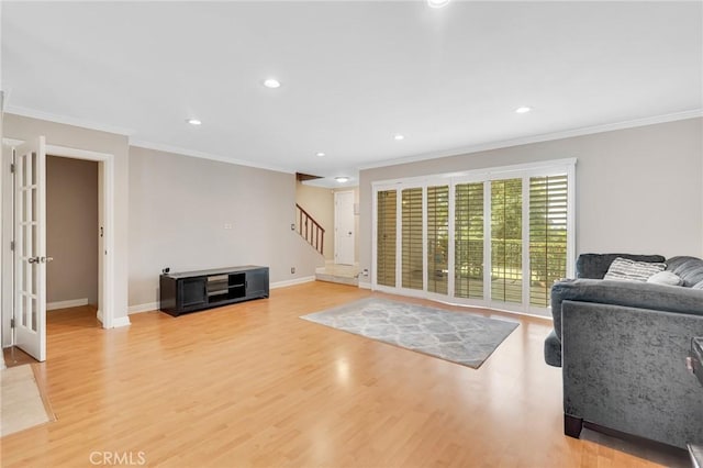 living room with light hardwood / wood-style floors, crown molding, and french doors