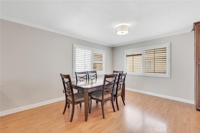 dining room featuring light wood-type flooring and ornamental molding