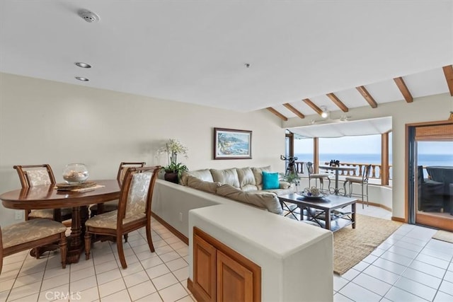 tiled living room featuring vaulted ceiling with beams and a water view